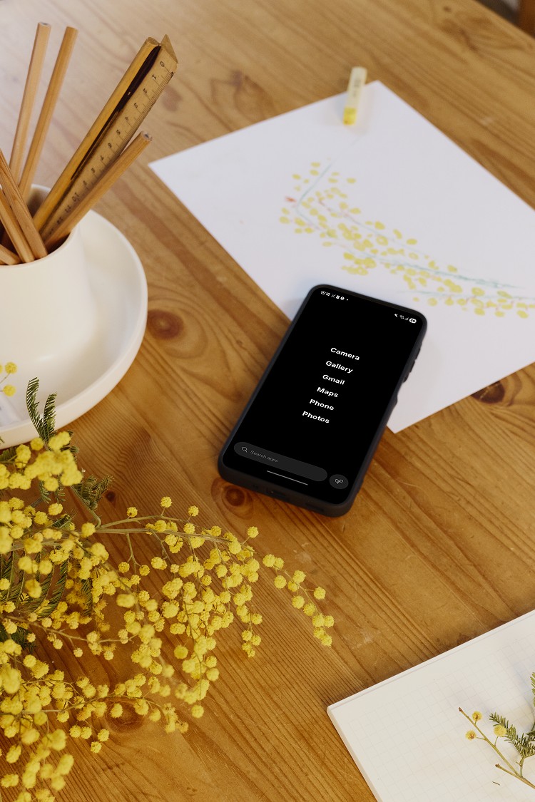 Un Balance Phone posé sur une table, avec son écran d'accueil minimaliste
